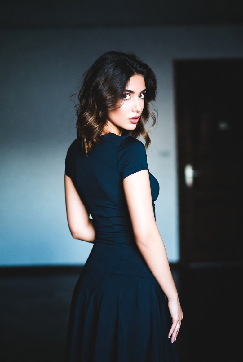 A professional portrait photograph captures a young woman with dark, wavy, sh...