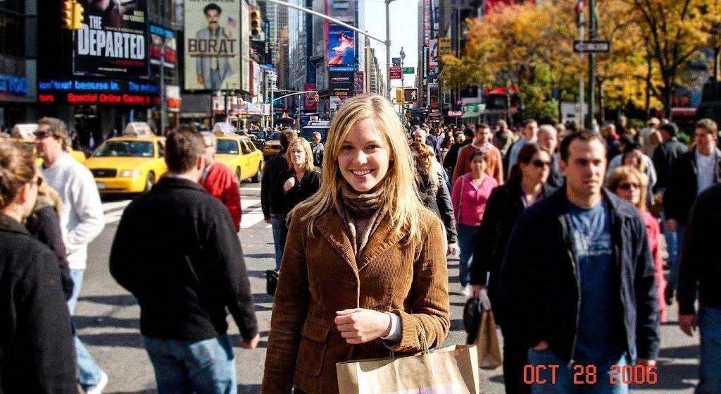 Generate a photorealistic image of Time Square on a saturday in Fall 2006, it...